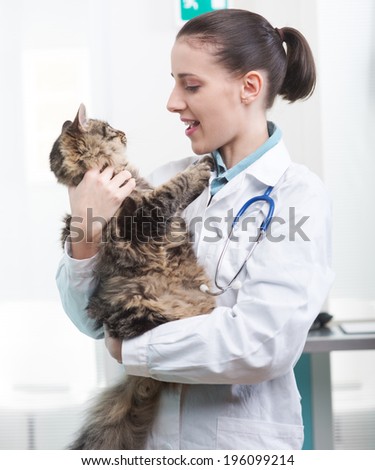Young female veterinarian with a cat in her arms