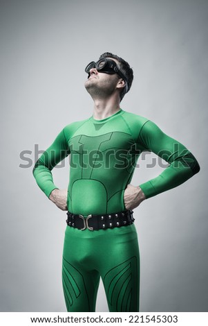 Funny lazy superhero looking up with arms akimbo.