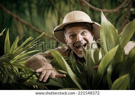 Surprised adventurer gasping and peeking through plants in the jungle.