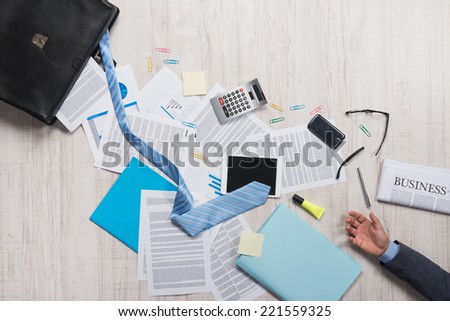 Businessman briefcase with paperwork and accessories on the floor, business failure concept.
