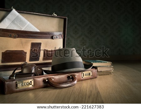 Photoreporter vintage open briefcase with old camera, newspaper and glasses.