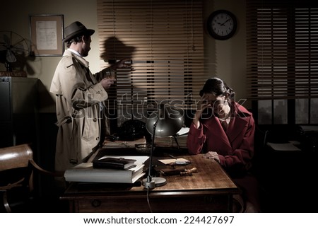 Confident detective standing in his office interviewing a young sad woman.