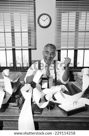 Cheerful vintage accountant surrounded by adding machine paper tape in his office.