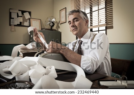 Professional accountant working with adding machine tape in vintage office.