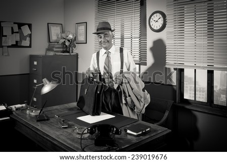 Businessman arriving at office holding briefcase and trench coat.