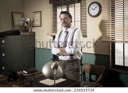 1950s confident director standing in the office with arms crossed.