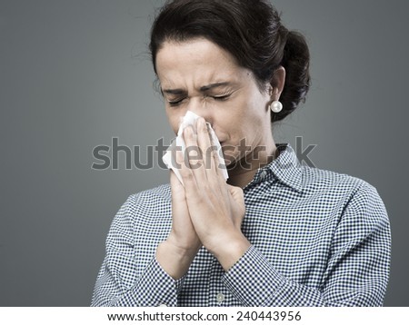 Vintage woman with allergy blowing her nose on an tissue