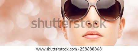 Young female fashion model wearing big sunglasses frontal portrait