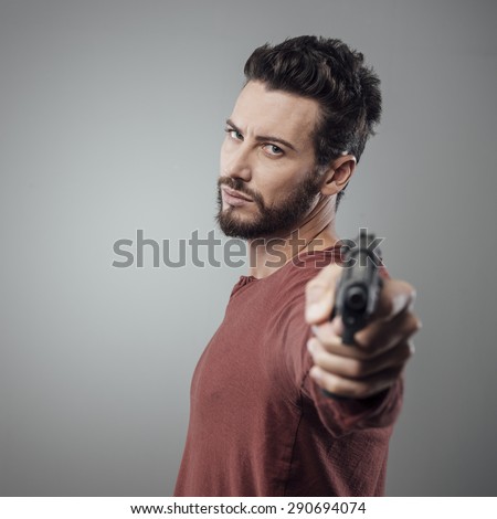 Confident aggressive man holding a gun, cool attitude