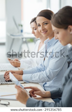 Business women team working at office desk using laptops and mobile devices
