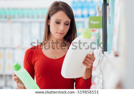 Woman shopping at the supermarket and comparing detergent products, she is reading labels Stock foto © 