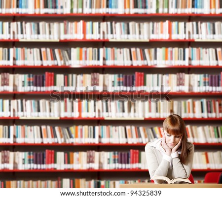 Portrait of a serious young student reading a book in a library