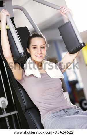 Young woman works out on weight-training machine