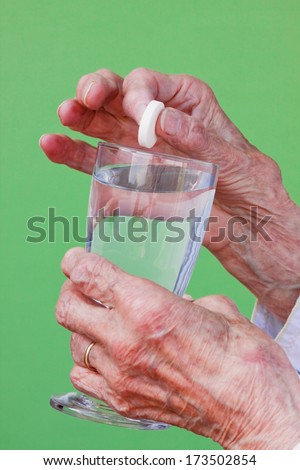 Senior woman ready to dissolve her pill in water and take it.
