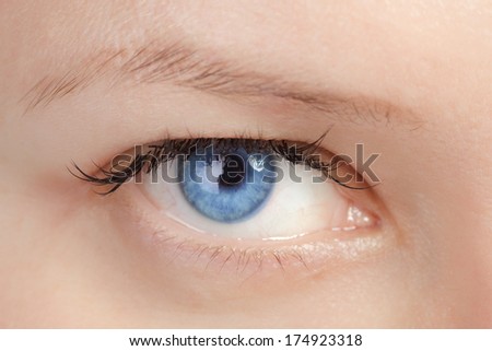 Blue eye with colored contact lenses close-up.