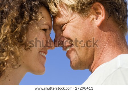 Real people. Real love. Romantic couple on the blue Caribbean sky background.