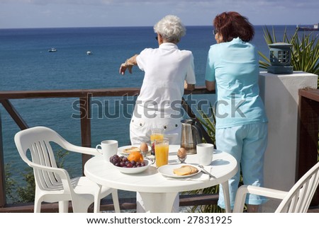 Happy retirement. Two senior ladies enjoying their Caribbean vacation at the hotel terrace.