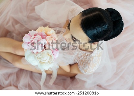 Wedding decoration blush vintage.  Portrait of young brunette bride with a bouquet on pink.