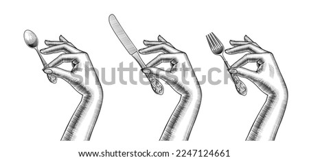 Engraved female hands holding cutlery are holding a table knife, a spoon and a fork for eating. Vintage engraving stylized drawing. Vector illustration
