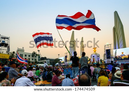 Bangkok, Thailand - January 4, 2014: Anti-government protesters wave big Thai flags at the Democracy monument in Bangkok