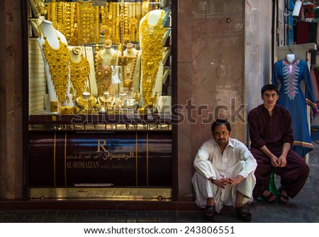DUBAI, UNITED ARAB EMIRATES - MAY 20, 2013: 2 merchants in front of gold shop in Gold Souk, Dubai.