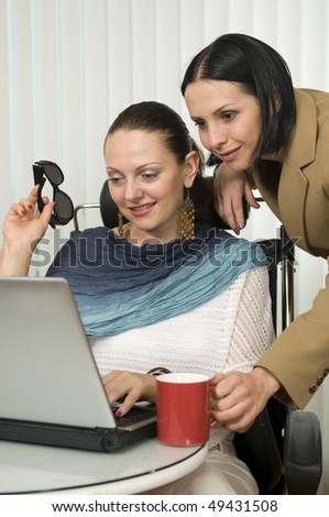 Teamwork: two young lady managers, working in office