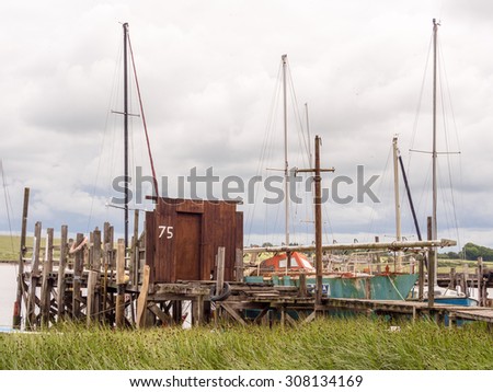 Skipool Creek, Thornton Cleveleys, Lancashire, UK. August 11th 2015. The old wooden huts at low tide at Skipool Creek, Lancashire, uk.