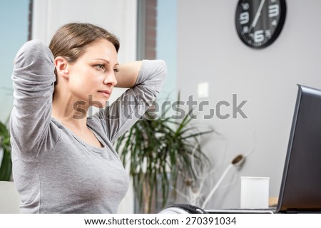 Photo of young woman stretching at home office
