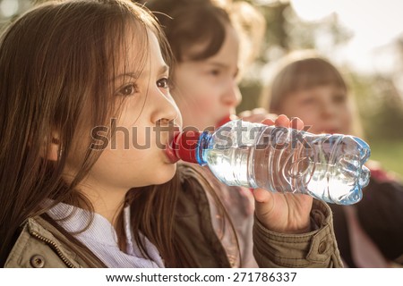 Photo of little girls drinking water from a PET bottle
