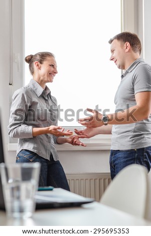 Two business people having relaxed conversation in the office