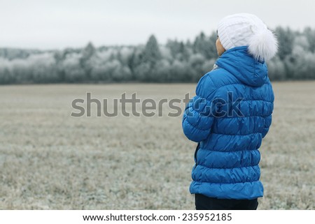 girl in a blue down jacket winter view from the back