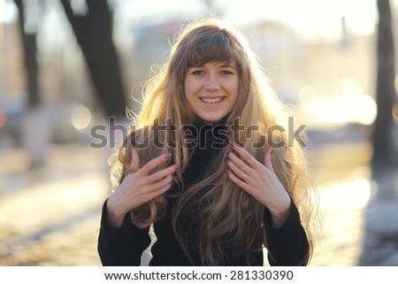 portrait of a girl with long blond hair outside in the spring