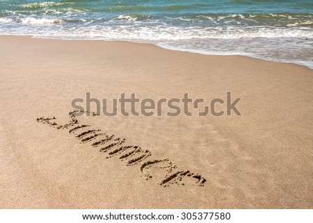 DRAWING ON THE SANDY BEACH WITH SEA WAVE IN SUMMER