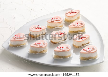 Small delicious individual creamy cheesecake desserts for a party or catered event served on a modern triangular platter