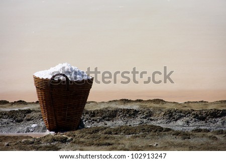 salt in the bamboo basket on the ground near salt pan, Thailand