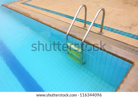 Swimming pool with steel ladder and plastic stairs