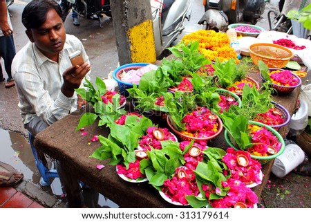DELHI, INDIA - JULY 20, 2015: Indian flower vendors offer their goods at flower market across Shri Gauri Shankar Mandir in Delhi, India. JULY 20 2015