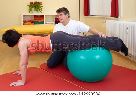 adult practicing poses on exercise ball with professional