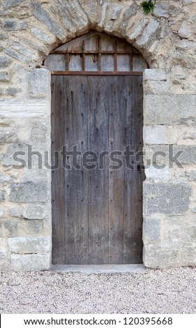 Ancient small door of an antique natural stone house. France, Provence