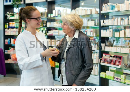Pharmacist helping a grateful senior patient woman in the pharmacy