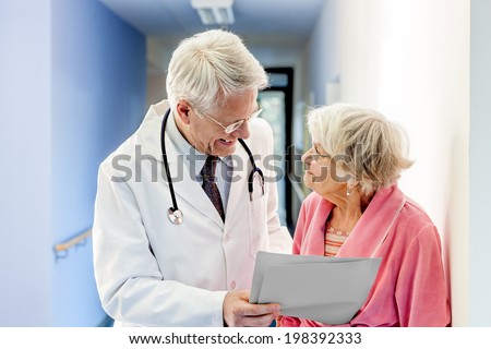Doctor Talking to Old Woman about Good Results at the hospital.