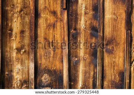 Exterior wooden rustic wall covered with paneling, made of vertical lumber boards, traditional architectural detail from Swiss Alps, close-up.