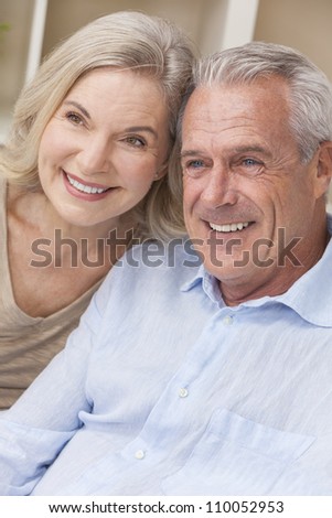 Happy senior man and woman couple sitting together at home smiling and happy