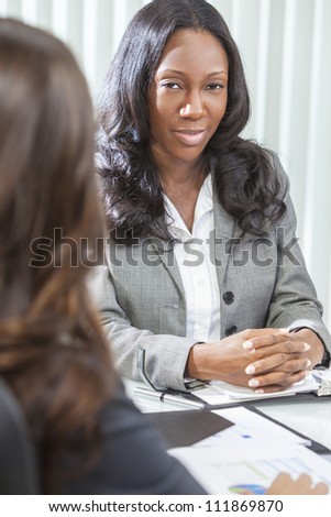 Young black African American woman or businesswoman in smart business suit having a meeting with her colleague