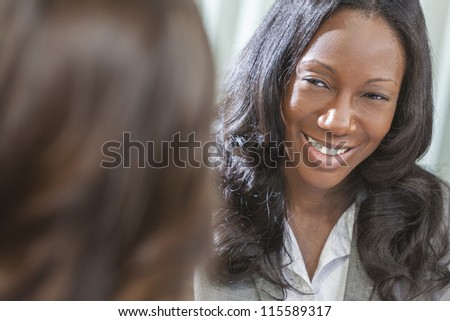 Young black African American woman or businesswoman in smart business suit having a meeting with her colleague
