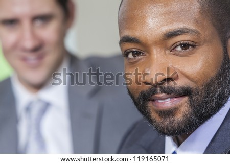 Successful African American businessman or man with his caucasian colleague behind him.