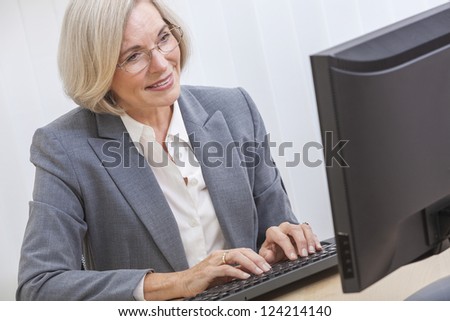 Senior woman typing using a computer at home or in an office