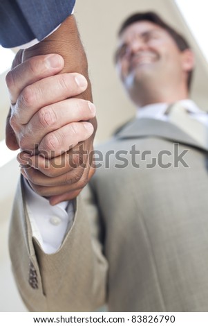Caucasian businessman or man shaking hands with an African American colleague doing a business deal