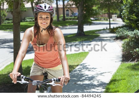 A young African American woman riding bicycle in the summer