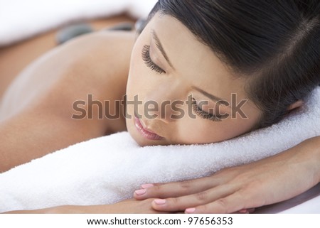 An Asian Chinese woman relaxing at a health spa while having a hot stone treatment or massage